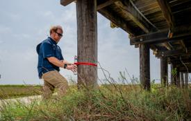 In addition to relying on data from more expensive Sentinels, engineering professor Dr. Bret Webb will deploy smaller storm surge and wave gauges in advance of a hurricane. They can be affixed to structures such as this pier on Dauphin Island.